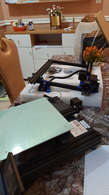 Printer frame and gantry parts freshly unboxed on a dining table